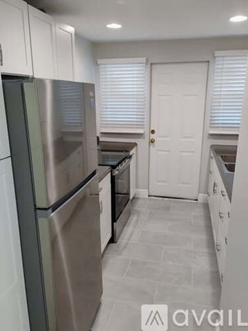 Ormond Beach apartment for rent - A kitchen with a stainless steel refrigerator and white cabinets.