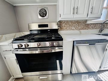 Peoria house for rent - A modern kitchen with a stainless steel stove and white cabinets.