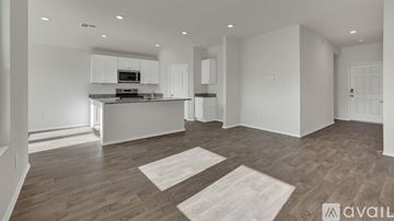 Seguin house for rent - A spacious kitchen with white cabinets and a wooden floor.