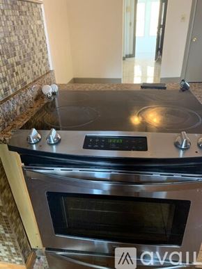 Worcester townhouse for rent - A modern kitchen with a stove top oven and a digital display.