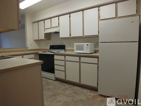 Seattle apartment for rent - A kitchen with white cabinets and a white fridge.