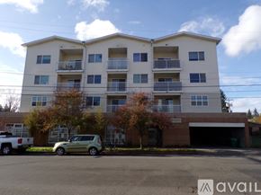 Seattle apartment for rent - A two-story apartment building with a parking lot in front.