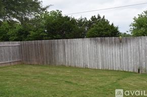 Leander house for rent - A wooden fence encloses a grassy yard.