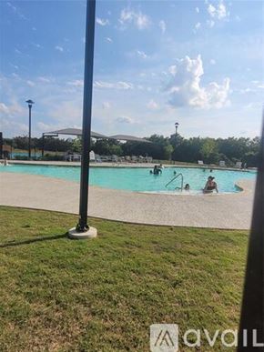Leander house for rent - A pool with people swimming and a pole in the foreground.