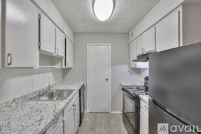 Nashville apartment for rent - A kitchen with a refrigerator, sink, and cabinets.