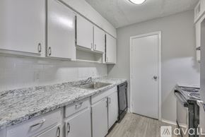 Nashville apartment for rent - A kitchen with white cabinets and a marble countertop.