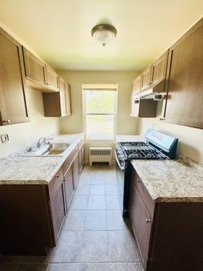 Washington Dc apartment for rent - A kitchen with brown cabinets and a granite counter top.