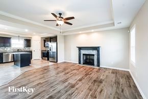 Clarksville house for rent - A spacious living room with a fireplace and wooden flooring.