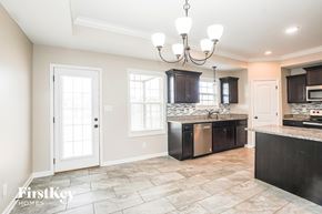 Clarksville house for rent - A kitchen with a tile floor and a chandelier hanging from the ceiling.
