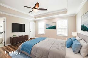 Clarksville house for rent - A bedroom with a bed, a ceiling fan, and a painting on the wall.