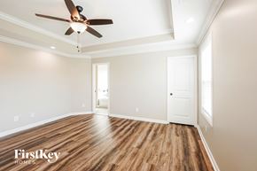 Clarksville house for rent - A spacious room with a ceiling fan and wooden flooring.