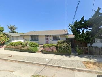 Santa Cruz apartment for rent - A house with a brown roof and a white door is surrounded by green bushes.