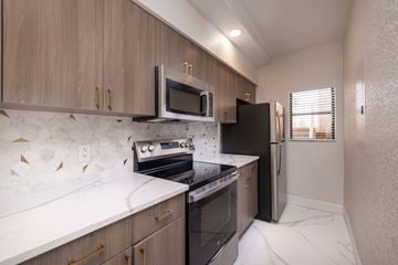 Kissimmee apartment for rent - A kitchen with a white counter top and wooden cabinets.