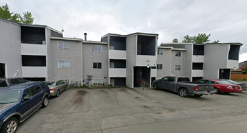 Anchorage apartment for rent - A parking lot with cars and apartment buildings.