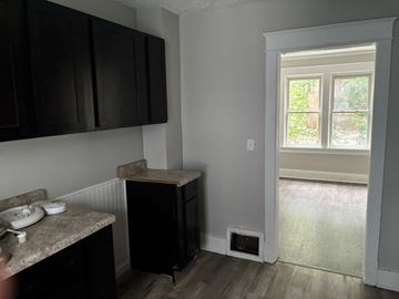 Akron house for rent - A kitchen with black cabinets and a window.