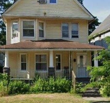 Cleveland house for rent - A yellow house with a porch and a front door.