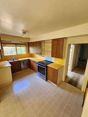 Victoria house for rent - A kitchen with a yellow counter top and a black stove.