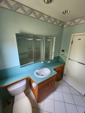 Victoria house for rent - A bathroom with a sink, toilet and mirror.