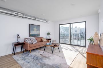 Salt Lake City apartment for rent - A living room with a brown couch, a small table, and a painting on the wall.