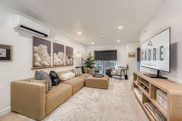 Salt Lake City townhouse for rent - A living room with a large couch and a flat screen TV mounted on the wall.