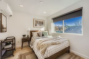 Salt Lake City townhouse for rent - A bedroom with a large bed and a view of a bridge outside the window.