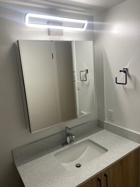 Calgary apartment for rent - A bathroom with a sink, mirror, and light.