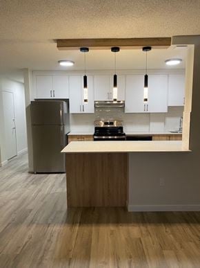 Calgary apartment for rent - A kitchen with a refrigerator, stove, and island.