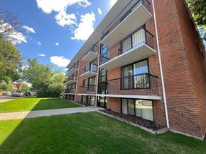 Calgary apartment for rent - A red brick building with a balcony on the second floor.