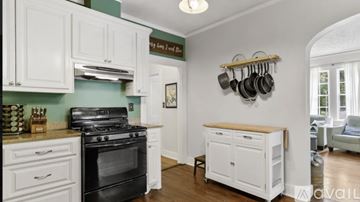 Jackson house for rent - A kitchen with white cabinets and a black stove top oven.