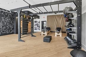 Atlanta apartment for rent - A gym with a wooden floor and a variety of equipment.