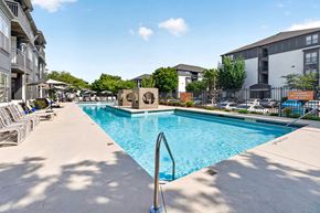 Atlanta apartment for rent - A large swimming pool surrounded by lounge chairs and buildings.