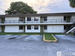 Tamarac house for rent - A silver car is parked in a parking lot in front of a building.