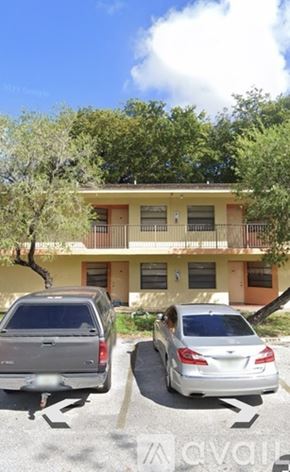 Tamarac house for rent - Two cars parked in front of a yellow building.