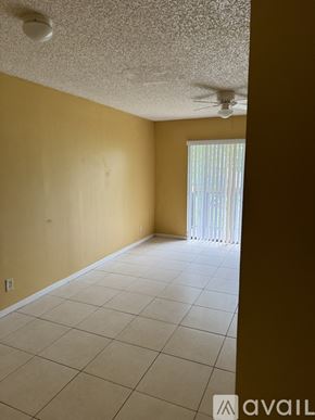 Tamarac house for rent - A room with a ceiling fan and a window with blinds.