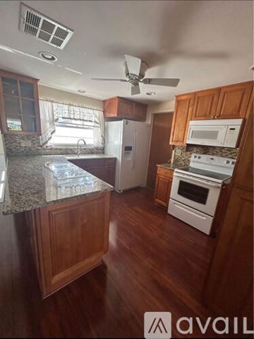 Tampa apartment for rent - A kitchen with wooden cabinets and a granite countertop.