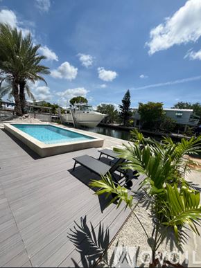 Little Torch Key apartment for rent - A swimming pool with a concrete edge and a blue water feature in the middle.