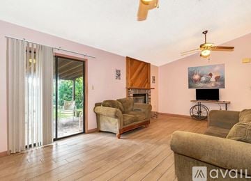Palm Bay house for rent - A living room with a fireplace, a bicycle, and a painting of a rabbit.