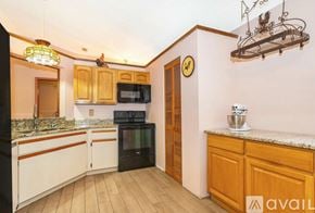 Palm Bay house for rent - A kitchen with wooden cabinets and a black oven.