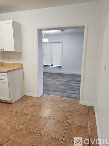 Plant City house for rent - A kitchen with white cabinets and a tiled floor.