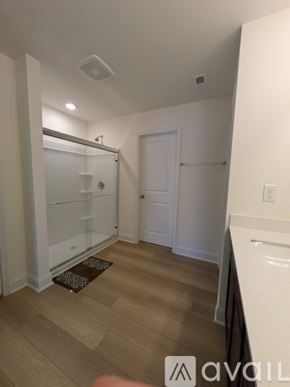 Angier house for rent - A room with a white door and a glass shower stall.