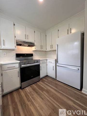 Rocky Mount house for rent - A kitchen with white cabinets and a wooden floor.