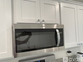 Lubbock house for rent - A silver microwave oven is installed in a white cabinet.