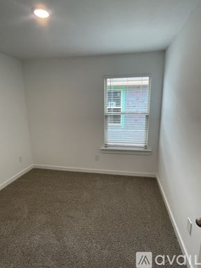 Lubbock house for rent - A carpeted room with a window and a door.