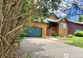 Camdenton house for rent - A house with a garage is surrounded by trees and bushes.
