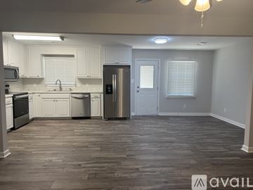 Millbrook house for rent - A kitchen with white cabinets and a wooden floor.