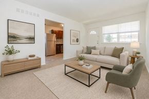 Voorhees apartment for rent - A living room with a white couch, a green armchair, and a coffee table.