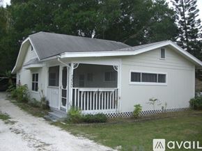 Sarasota house for rent - A white house with a porch and a dirt path leading to it.