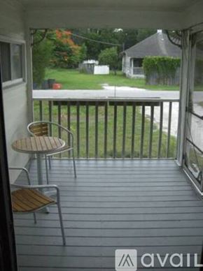 Sarasota house for rent - A balcony with a table and chairs overlooking a yard.