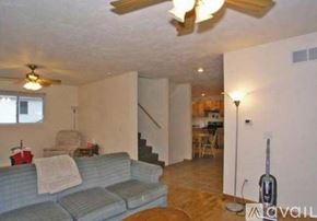 Kalamazoo house for rent - A living room with a couch, a fan, and a guitar.