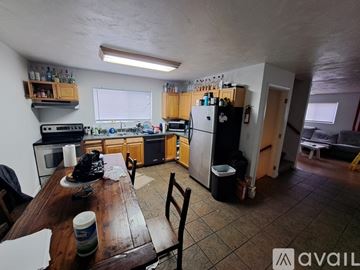 Kalamazoo house for rent - A kitchen with wooden cabinets and a black fridge.